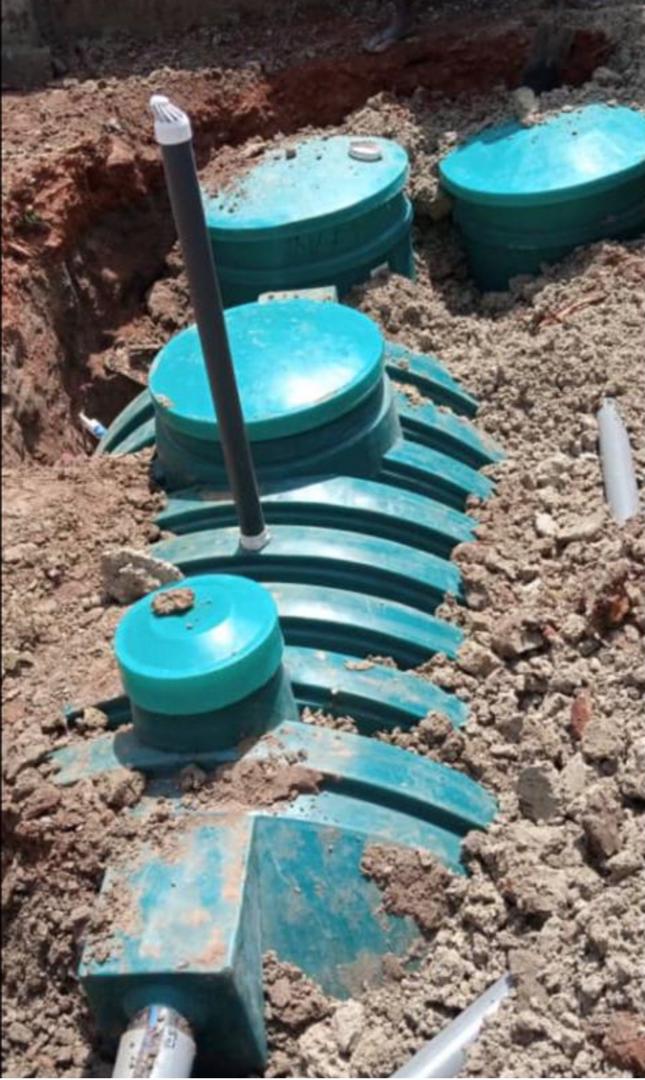 Green biodigester septic tank installed in trench with vent pipe