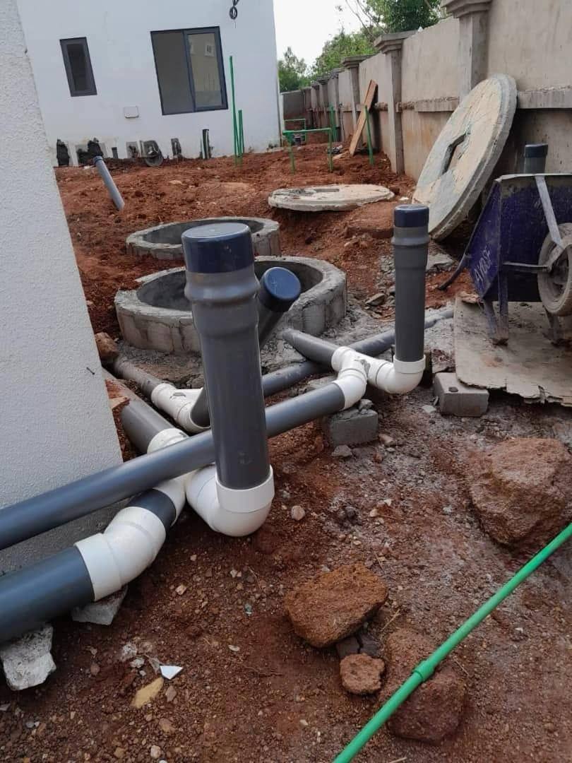 External PVC drainage pipes and concrete manholes during septic installation